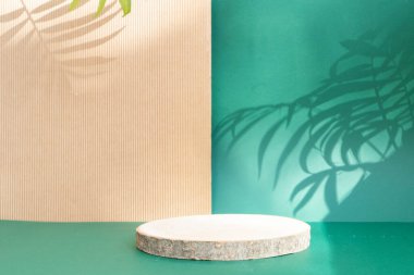 Asgari modern ürün podyumu, ahşap podyum, palmiye yaprakları ve gölge örtülü yeşil ve desenli kahverengi zemin üzerine kuruludur.