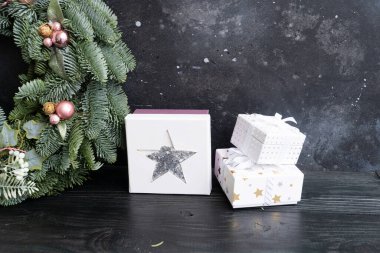 Koyu arkaplan üzerinde hediye kutuları olan gümüş ve beyaz süslemeler, boşluğu kopyala