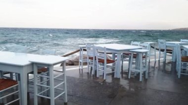 Yunanistan 'ın Mykonos adasında yaz aylarında deniz ve deniz kenarındaki kafe masası