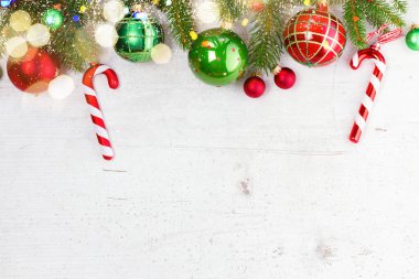 Kırmızı ve yeşil süslemeli Evergreen dalları, Bokeh ile beyaz zemin üzerinde düz kenarlı