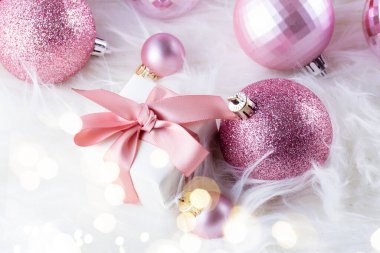 Pembe Noel süslemeleri ile hediye kutusu beyaz kürk arka plan üzerinde Kapat