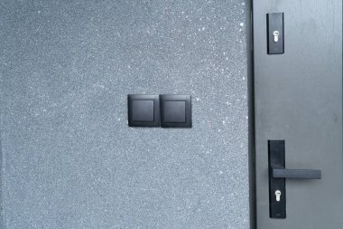 Siyah beton duvarda çift elektrik düğmesi,