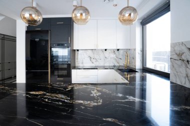 Bar tezgahı olan beyaz ve siyah modern mutfak odası.