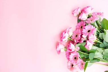 düğün ya da anneler günü geçmişi, pembe arka planda bir buket gül ve herberalar.