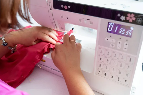Designer or little atelier owner sewing on sewing machine