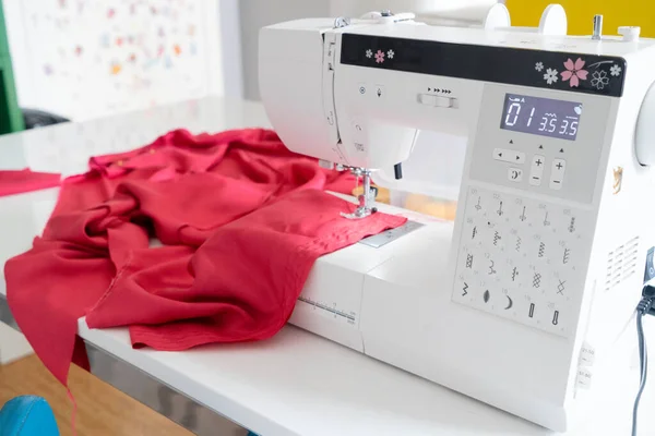 Sewing background with unfinished dress in sewing machine