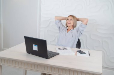Modern dizüstü bilgisayarla çalışan yaşlı kadın, rahatlatıcı an, teknoloji ve yaşlılar yaşam tarzı kavramı