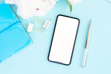 Ev ofis büro Şakayık çiçekleri ve modern telefon, üstten görünüm