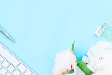 Ev ofis çalışma alanı beyaz modern klavye ve şakayık çiçekleri ile yat, mavi arka plan üzerinde alanı Kopyala