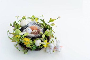 Yuvasında renkli yumurtalar, laleler ve tavşanlı Paskalya sahnesi.