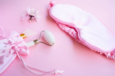 Uyku maskeli bahar çiçekleri ve gua sha masaj aleti, uyku bozukluğu konsepti, uykusuzluk terapisi, uyku sorunları ve yoksunluk.