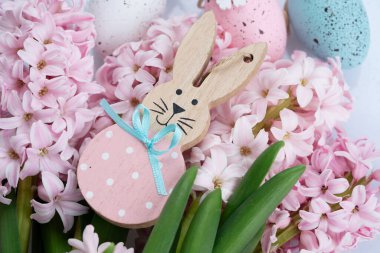Paskalya sahnesinde taze sümbül çiçekleri ve yumurtalı Paskalya Tavşanı.