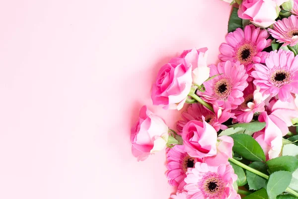 düğün ya da anneler günü geçmişi, pembe arka planda bir buket gül ve herberalar.