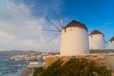 Mykonos Adası 'nın ünlü yel değirmeni ve günbatımı güneşli deniz manzaralı şehir, Yunanistan Mykonos Adası