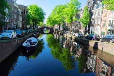 Amsterdam 'ın kanal halkası üzerindeki köprüsü. Eski Avrupa kentinde, Amsterdam bahar manzarası. Ağaç yemyeşil.