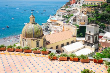 Positano şehri manzarası. İtalya 'da yaz günü kilise kubbesi olan ünlü bir İtalyan tatil köyü.