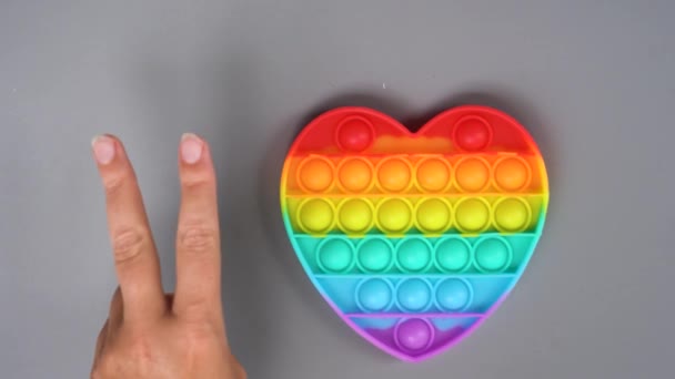Oyuncak Birisi Elinde Gökkuşağı Renginde Silikon Oyuncakla Rahatlasın Diye — Stok video