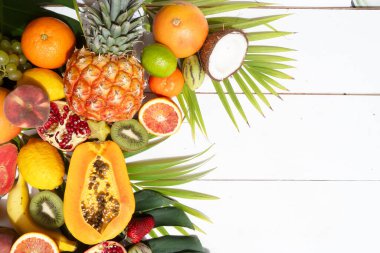 Beyaz ahşap zemin üzerine tropikal meyvelerin yaz karışımı ve fotokopi alanı