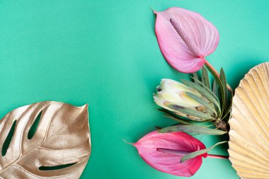 Açık yeşil zemin üzerinde tropikal yapraklar ve çiçekler, kopyalanmış yaz arkaplanı