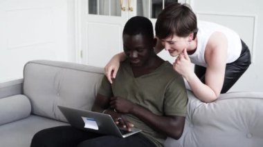 Genç çift birlikte dizüstü bilgisayar izliyor, iyi haberler alıyor ya da bir şey seçiyor.