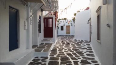 Myconos, Yunanistan 'ın Paros adasında güneş ışığıyla denize açılan tipik beyaz cadde.