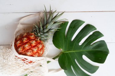 pinapple on white wooden table in bag clipart