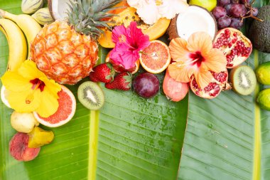 Yeşil yaprağın üzerinde tropikal meyve karışımı ve fotokopi alanı