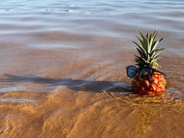 Ananas plajda güneş gözlüğü ve kulaklıkla