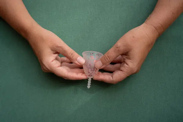 stock image Hands holding menstrual cup over violet background, eco friendly and zero waste solution