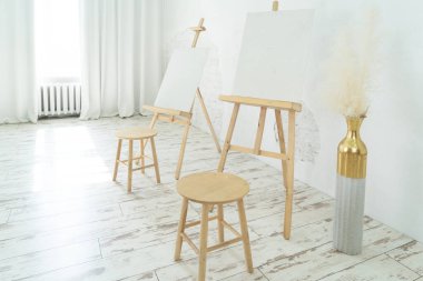 Bu parlak sanat stüdyosunda büyük bir masa, rahat bir sandalye ve yaratıcılığı teşvik eden renkli sanat eserleri bulunur.