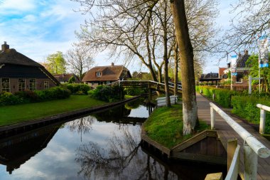 Hollanda 'nın kırsal kesimlerinde eski küçük bir kasaba olan Giethoorn köprüleri, Hollanda kanalları.