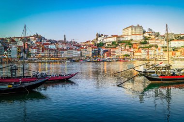 Douro nehrinin üzerinde gün batımında eski Porto kasabasının renkli manzarası. Oporto, turistik Akdeniz şehri