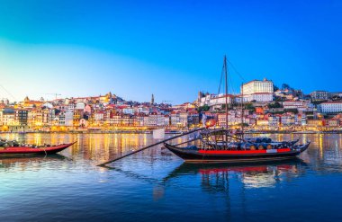 Douro nehrinin üzerinde gün batımında eski Porto kasabasının renkli manzarası. Oporto, turistik Akdeniz şehri