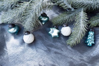 Yılbaşı süslemeleri gümüş kumaş zemin üzerinde yeşil ve mavi renkte, tatil süslemeleri için hazır..