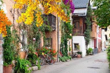 Göz kamaştırıcı dağlarla yukardaki bulutlar arasında güzelce yuva yapmış güzel bir Hallstatt göl kenarı köyü, Avusturya