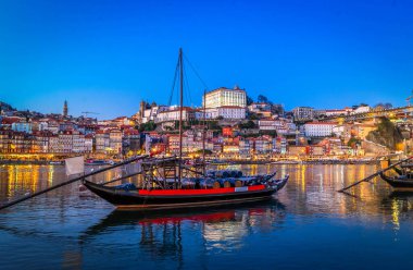 Douro nehrinin üzerinde gün batımında eski Porto kasabasının renkli manzarası. Oporto, turistik Akdeniz şehri