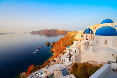 Yunanistan 'ın Aegan denizi ve kalderasına karşı mavi kubbeleri olan geleneksel Yunan köyü Oia of Santorini' nin caddesi, web pankartı