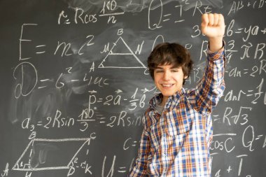 Genç çocuk kara tahta üzerinde karmaşık matematik formülleri ile fikir bulma