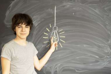 Tennage düşünme ve boş kara tahta bir fikirle arka planda elde çocuk