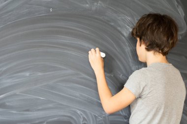 Elinde boş siyah kurulu yazma tebeşir ile genç çocuk