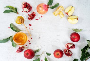 rosh hashana holiday - honey with apple and pomergranate over white desk background, top view frame with copy space