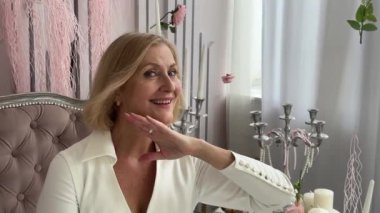 Bir kadın evinde dinlenirken gua sha aleti kullanarak rahatlatıcı ve canlandırıcı bir yüz masajı deneyimi yaşar.