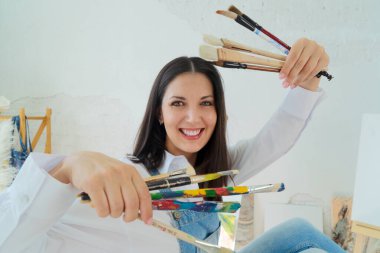 Yetenekli ve yetenekli bir sanatçı, canlı boya fırçalarını ilham verici bir stüdyoda gururla sergiliyor.