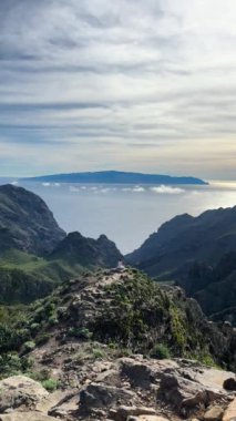 Huzurlu dağ manzarası. Okyanusa bakan bir kadın. Yürüyüşçüler ve doğa severler için mükemmel.