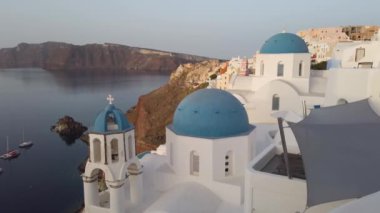 Oia 'nın, beyaz kilise çanlarının, mavi kubbelerin ve deniz manzaralı volkan kalderasının çekimleri, Yunanistan' ın Santorini adasının çekimleri