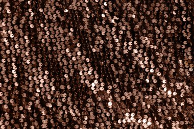 Güzel bir Noel ışığı arka planı. Soyut parıltı bokeh ve dağılmış altın pullar, yılın rengi 2025 mocha mus.