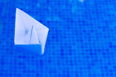 Yüzeyinde dinlenen beyaz bir şamandırası olan sakin bir mavi yüzme havuzu rahatlatıcı bir ortam yaratıyor..