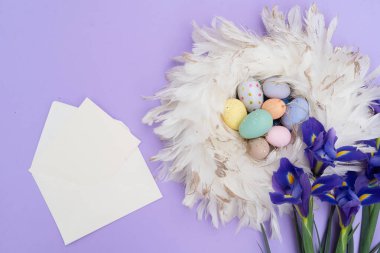 Paskalya sahnesinde menekşe arkaplan üzerinde renkli yumurtalar, kopyalama alanı