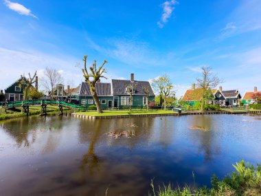 Hollanda 'nın geleneksel yel değirmeni Zaanse Schans yaz günbatımında su üzerinde, Hollanda