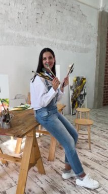 Bir sanatçı, geniş ve iyi ışıklandırılmış bir sanat stüdyosunda tutkuyla güzel bir çiçek başyapıtı yaratıyor.
